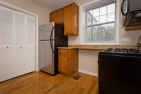 a kitchen with a refrigerator and a sink and a window